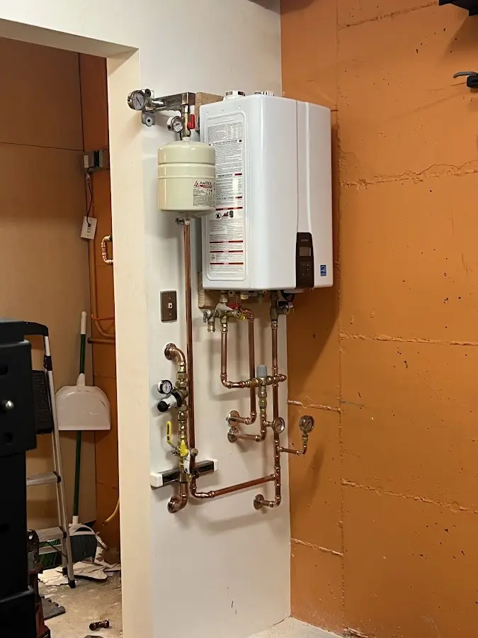 Plumbing technician inspecting water heater connections in Evansville